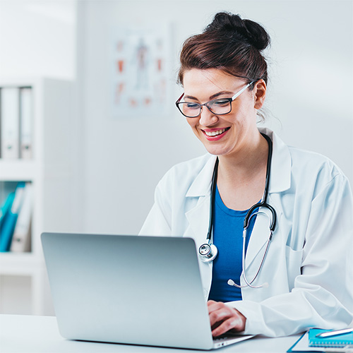 happy-female-physician-behind-computer
